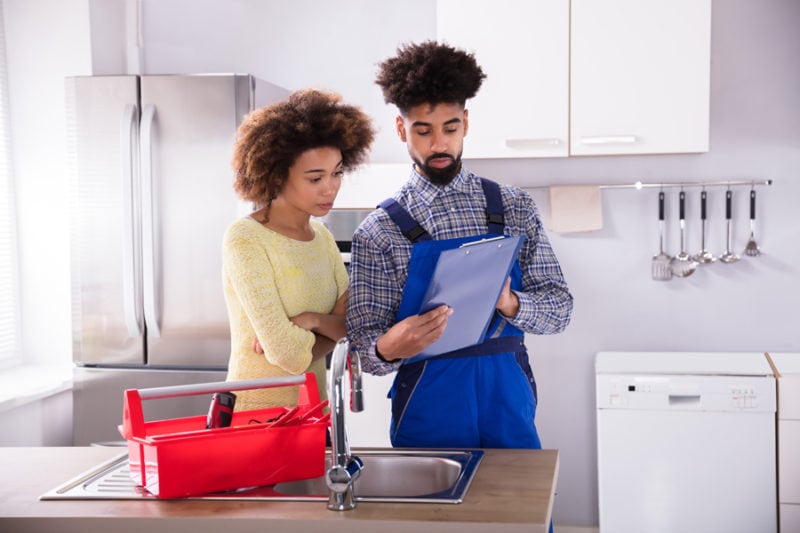 Woman Signing Invoice In Kitchen