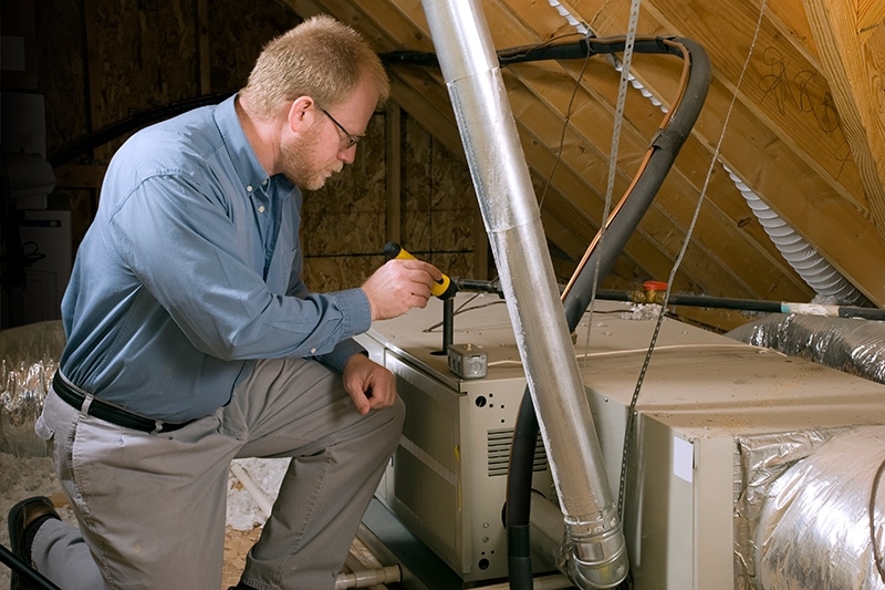 How Can I Make My Furnace Last Longer? Man working on a furnace.