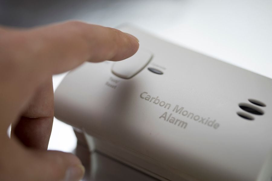A person presses a CO alarm. Learn the Facts About Carbon Monoxide.