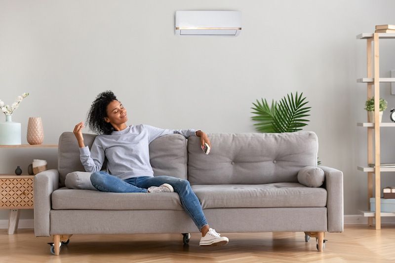 A woman enjoys her home on a couch. What Accessories Can Help With My Indoor Air Quality?